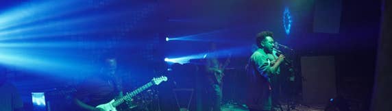 Zeruabbel Molla and his band performing on stage with colorful lights and a guitarist in the foreground.